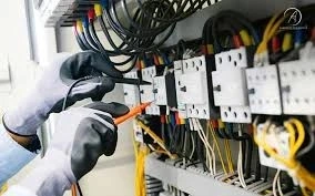 Man testing commercial electrical panel wires.