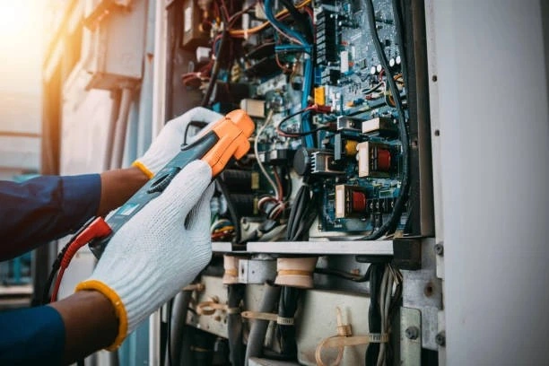 Technician testing an industrial control panel.
