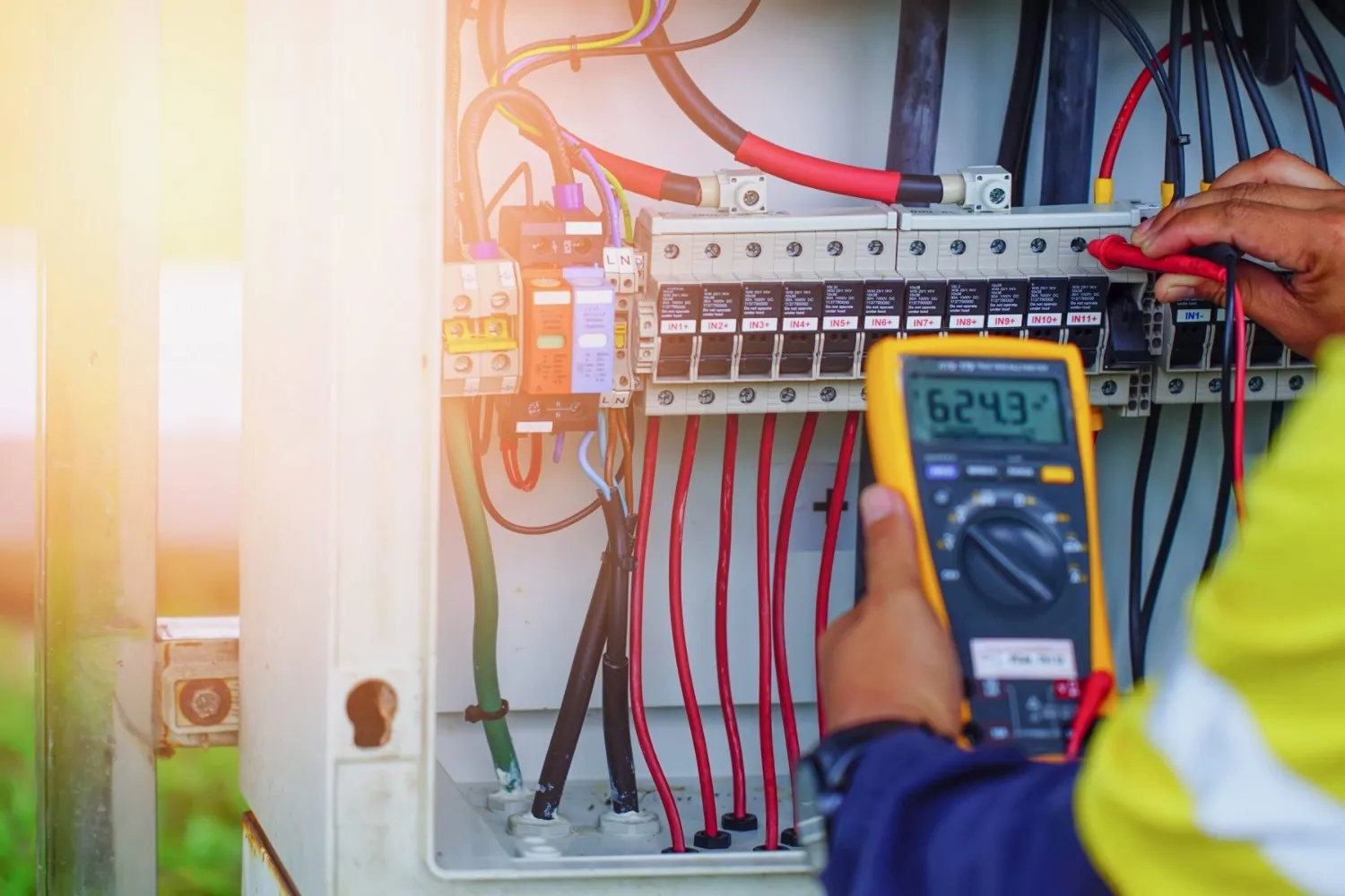 Electrician checking industrial control panel.