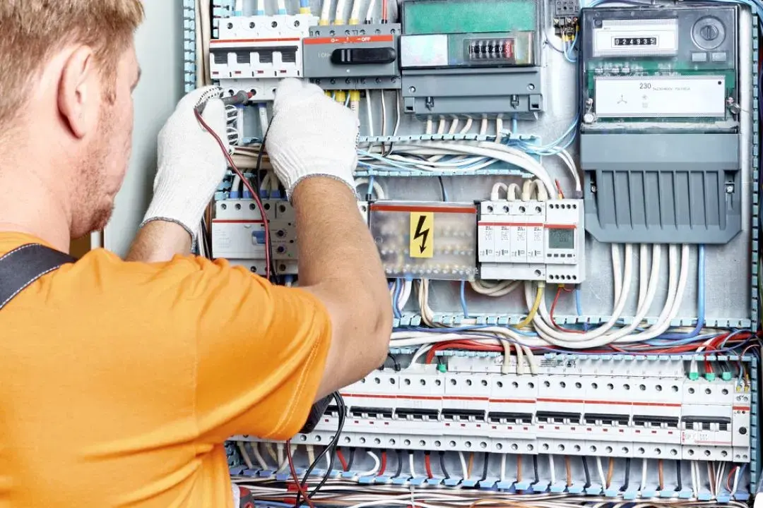 Electrician working on electrical panel.