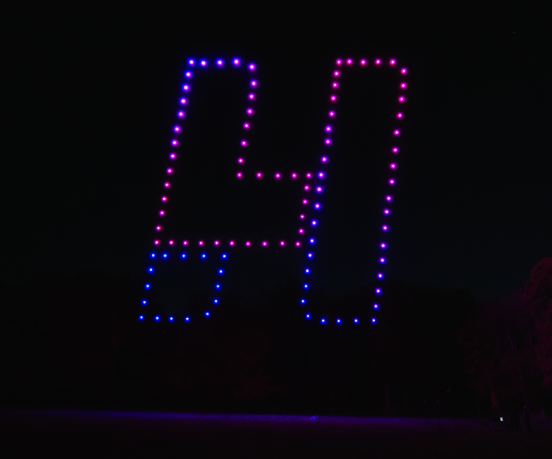 Bunte Drohnenlichter in rechteckiger Form, die nachts am Himmel leuchten.