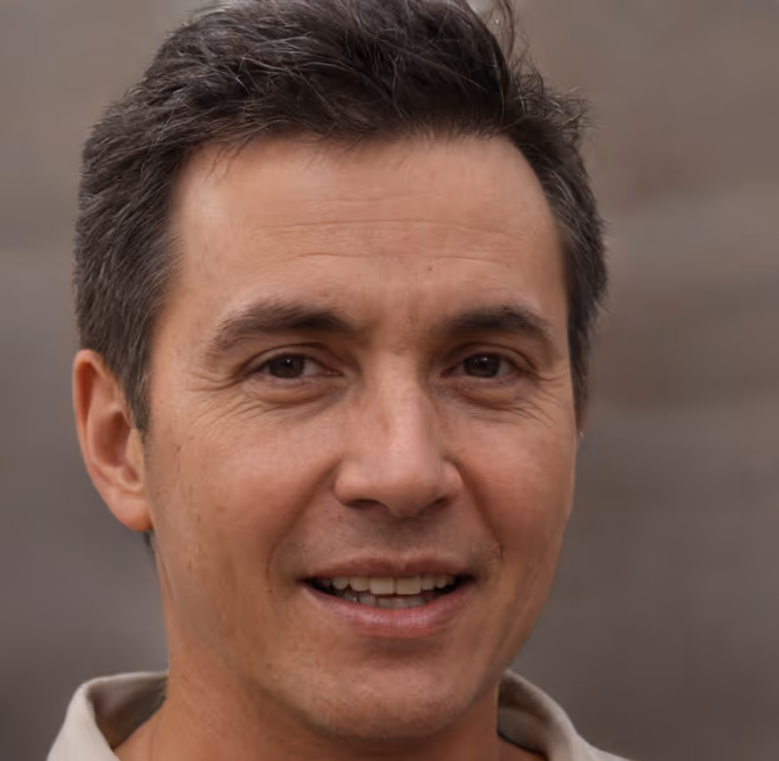 Smiling man with short dark hair and brown eyes wearing a beige shirt.