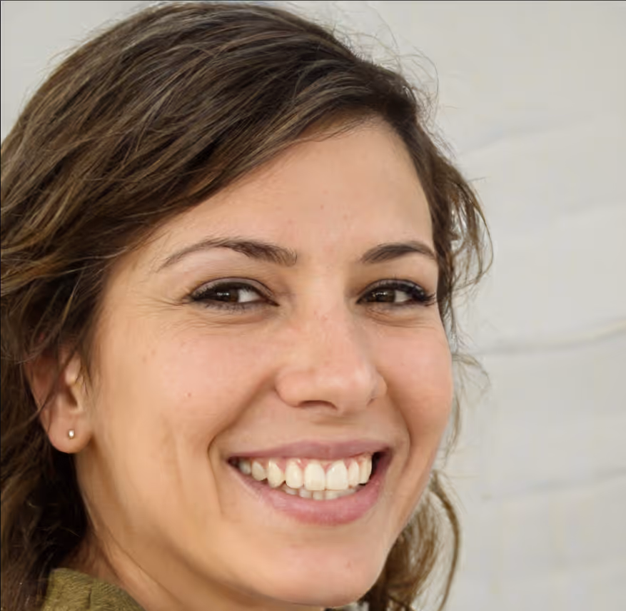 Close-up of a smiling woman with brown hair and a small earring against a light background.