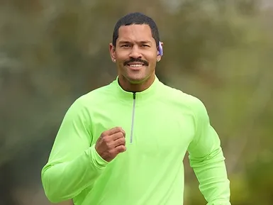 Matthew training outside in a green running top.