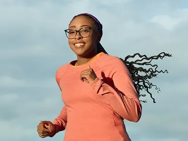 Alana running outside in a pink long sleeved top.