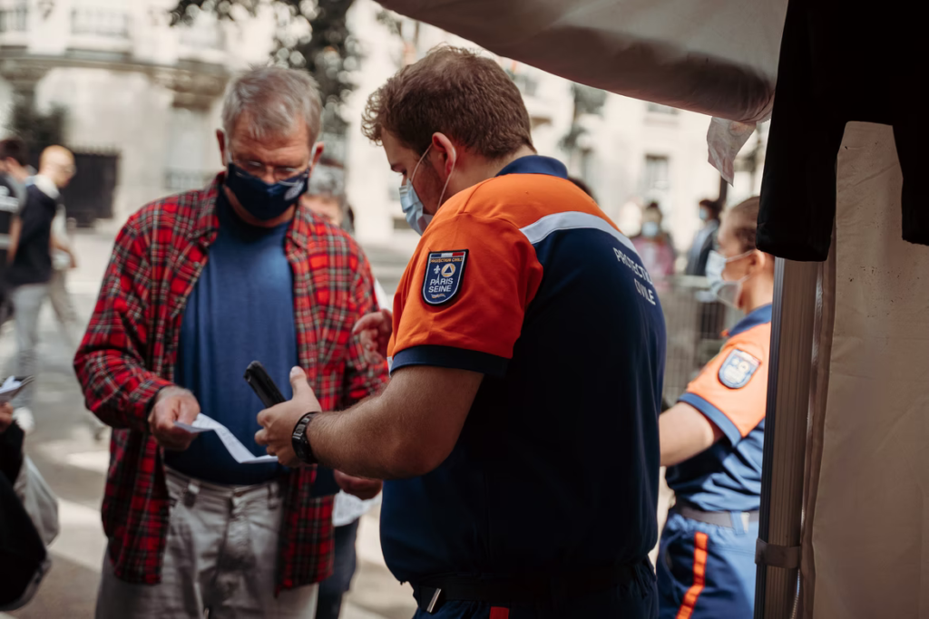 Homme contrôlant le pass sanitaire d'un participant à un évènement