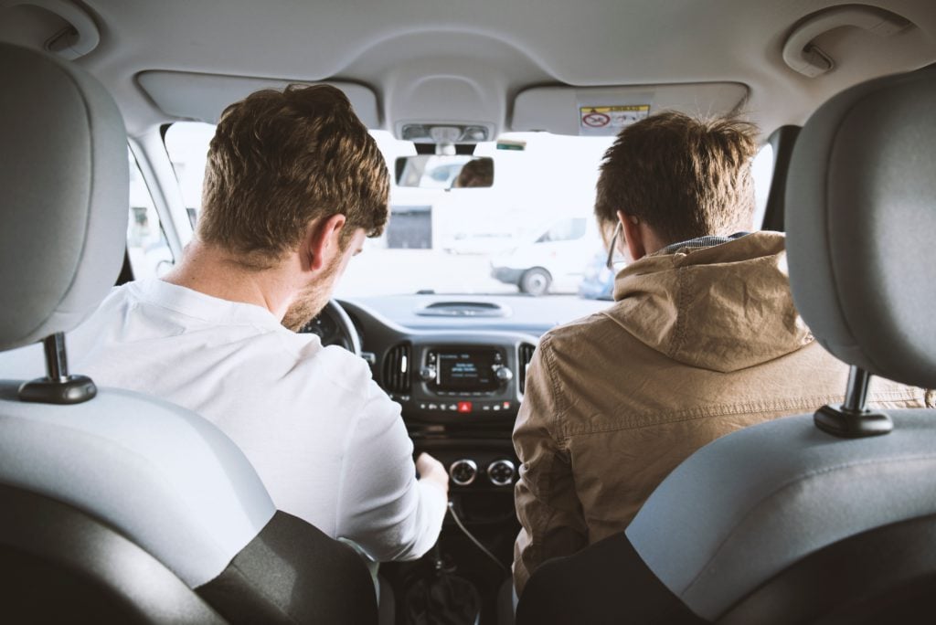 deux hommes pris de dos dans une voiture