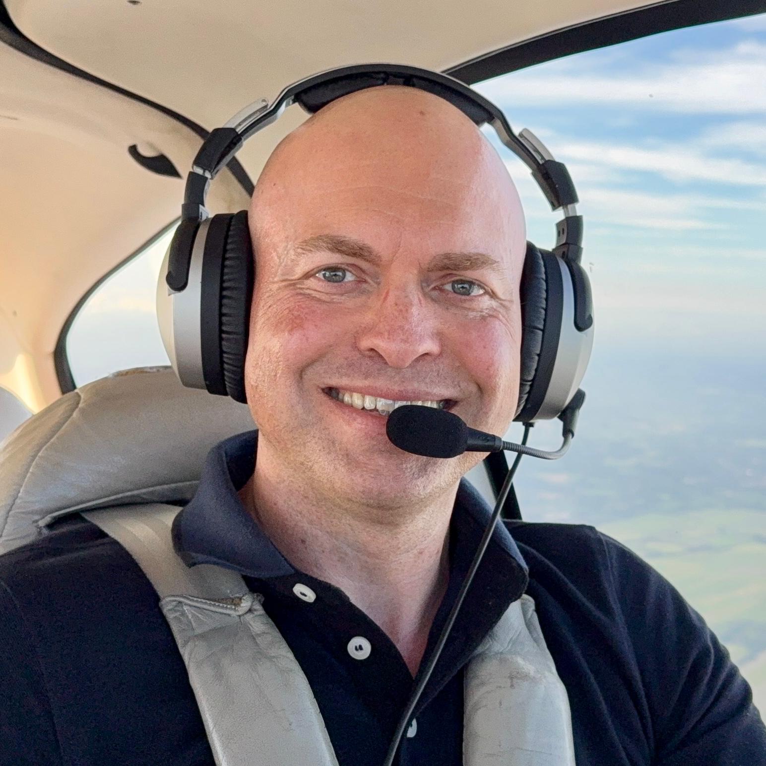 Per Gerlach sitzt mit Headset in einem Flugzeug
