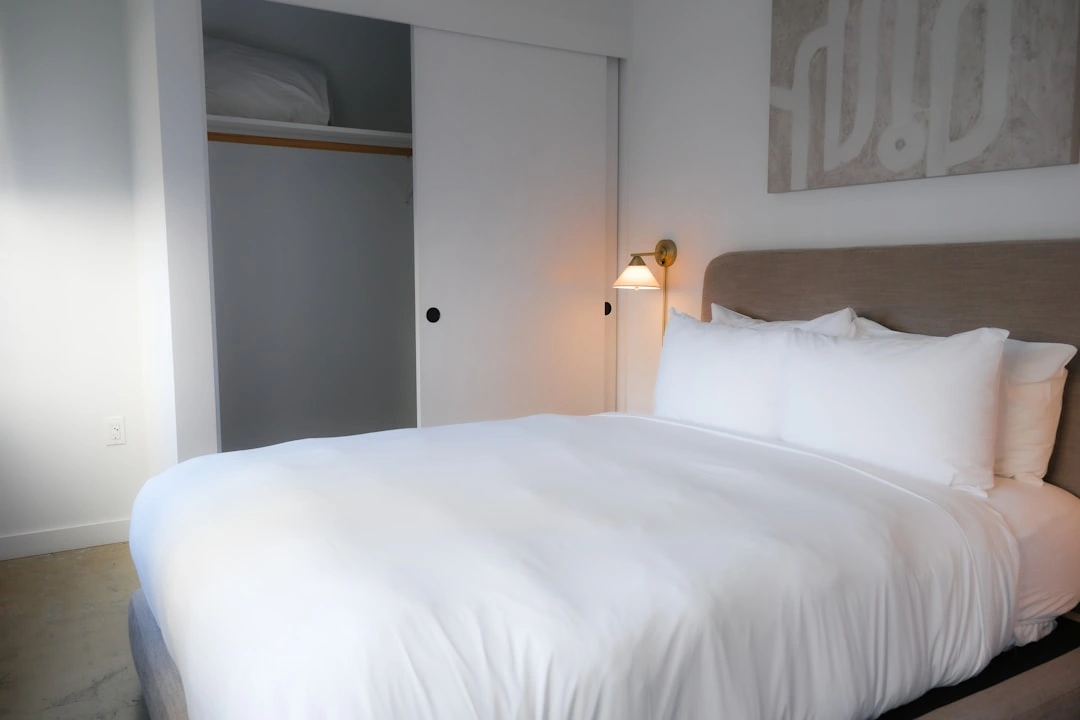 cozy and clean organized guest bedroom with fresh towels on the bed cozy and clean organized guest bedroom with fresh towels on the bed