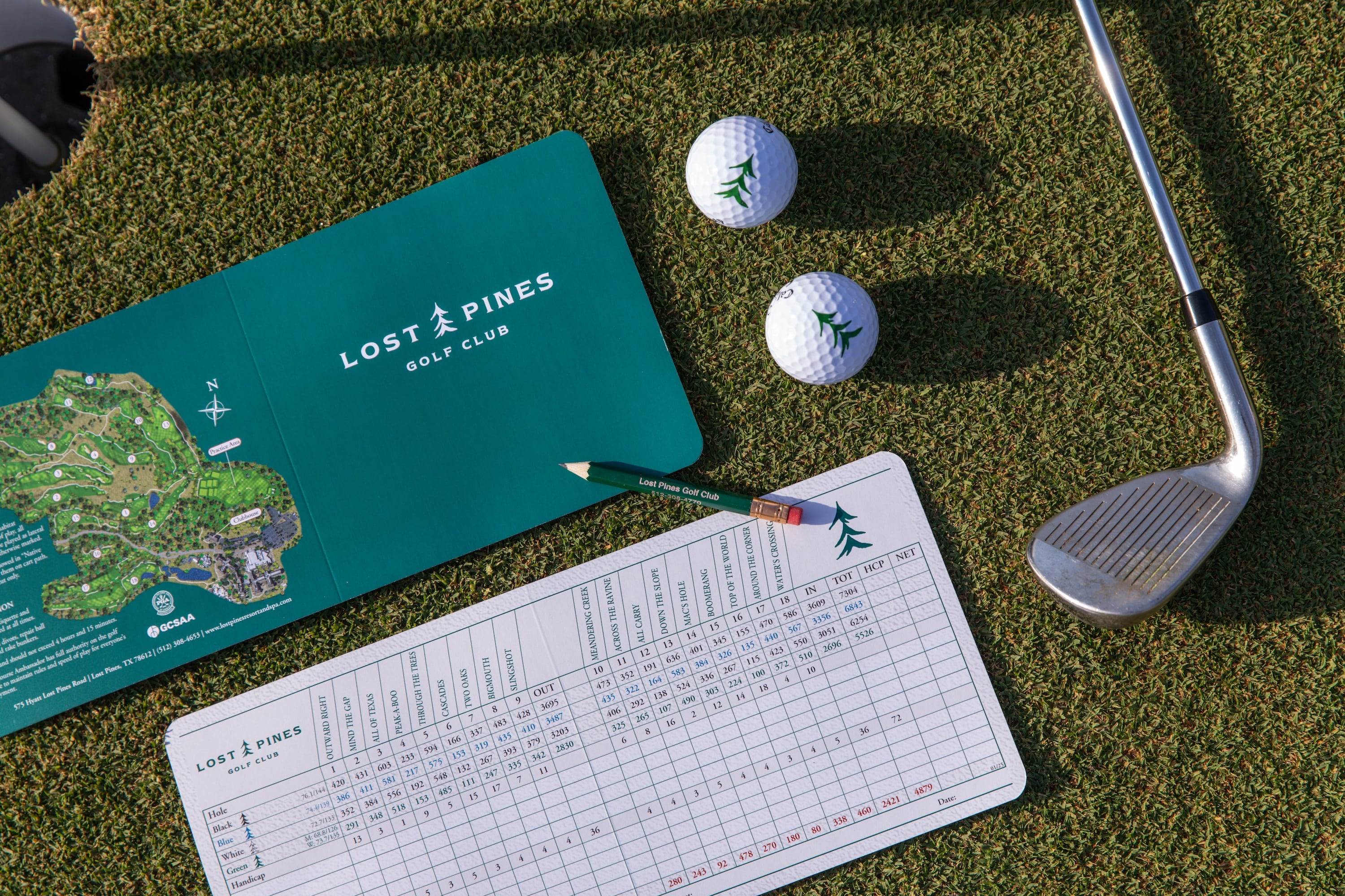 Golf card, golf balls, and clubs on Lost Pines Golf Club course