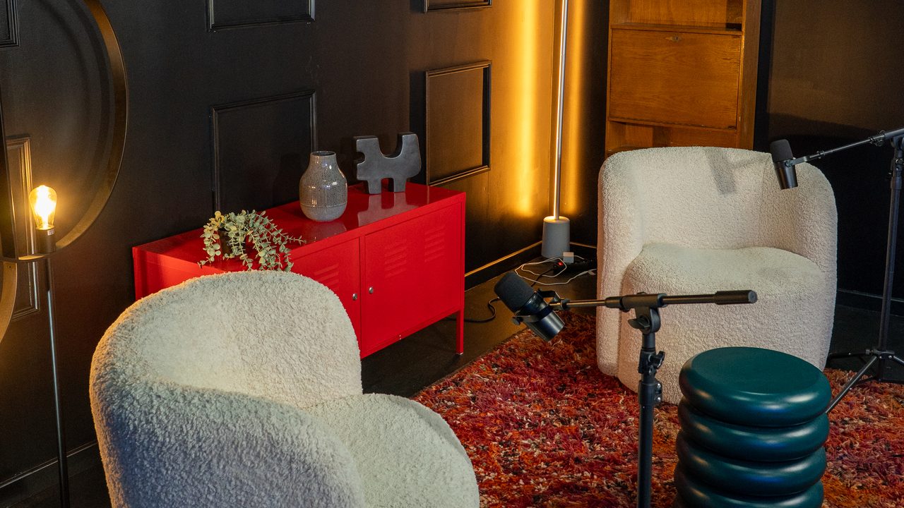 Un décor du studio VPS : fauteuils blancs, micros sur pied et murs noirs