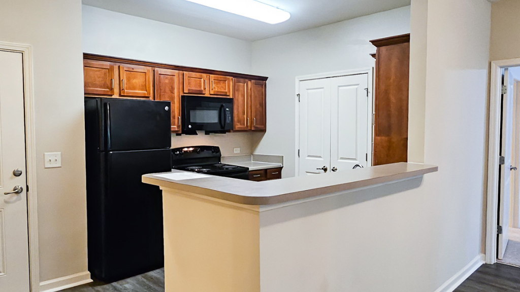 Kitchen with breakfast bar, wood cabinets, and black appliances