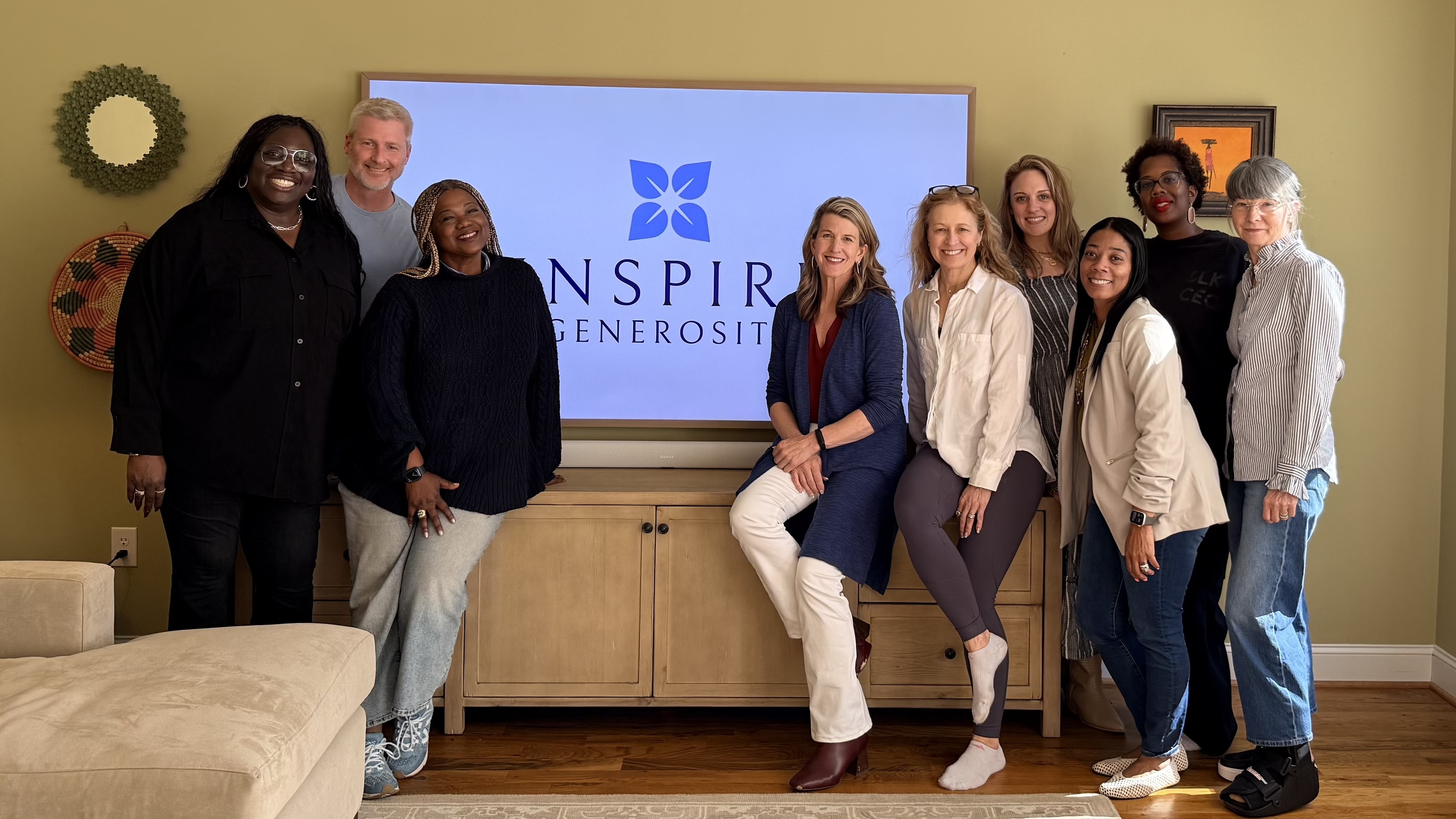 Joanna Hogan with a group of nonprofit leaders in front of an Inspire Generosity screen