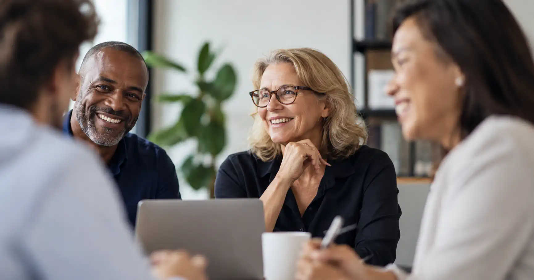 Board members smiling and talking together around a table