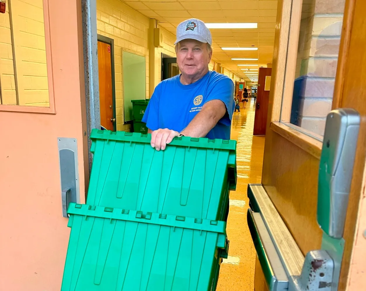 Rotary volunteer wheels out snack packs for delivery to local school