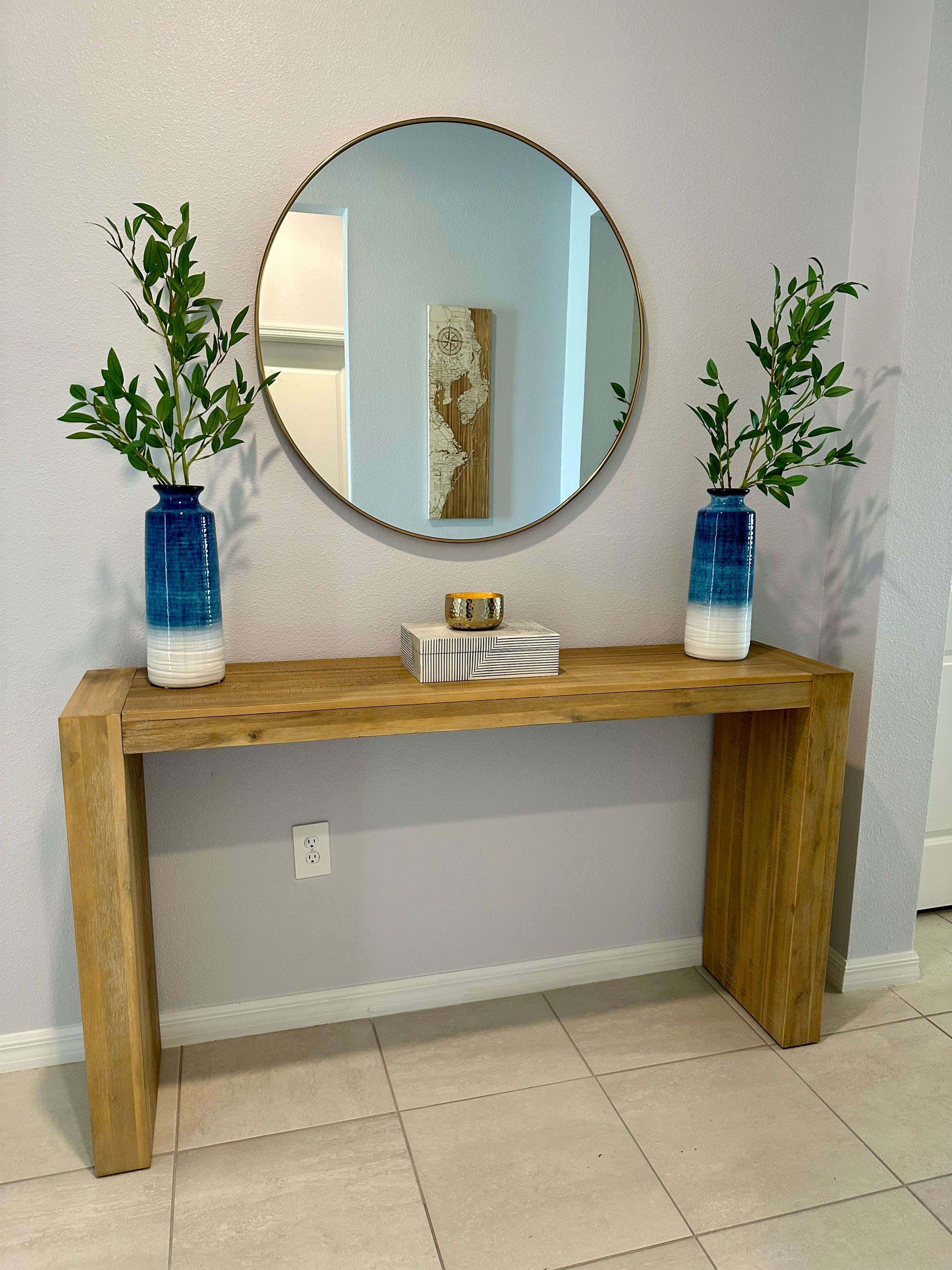 Primary bedroom staging with layered linens and warm wood tones