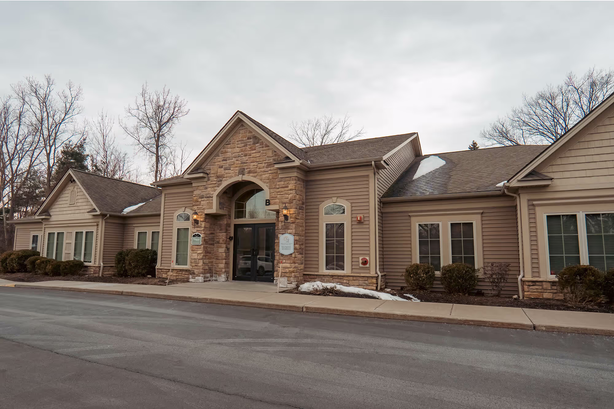 A large brown house with a black door and windows.