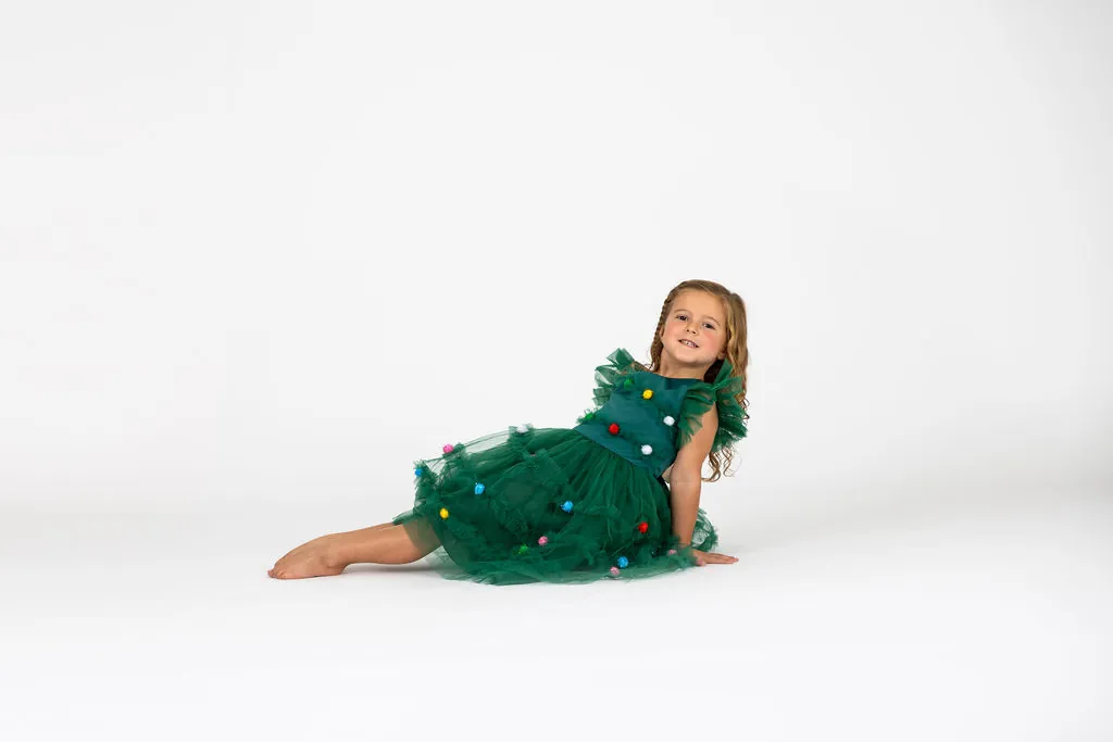 Little Danceology dancer in a green tutu dress lying on the floor smiling