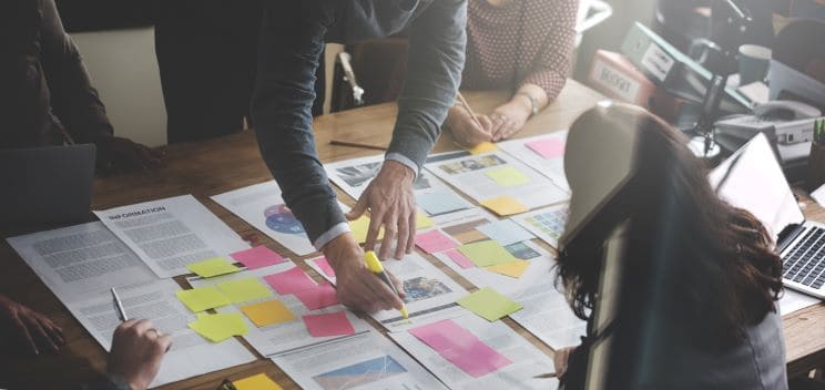 Team brainstorming with colorful sticky notes and documents on table