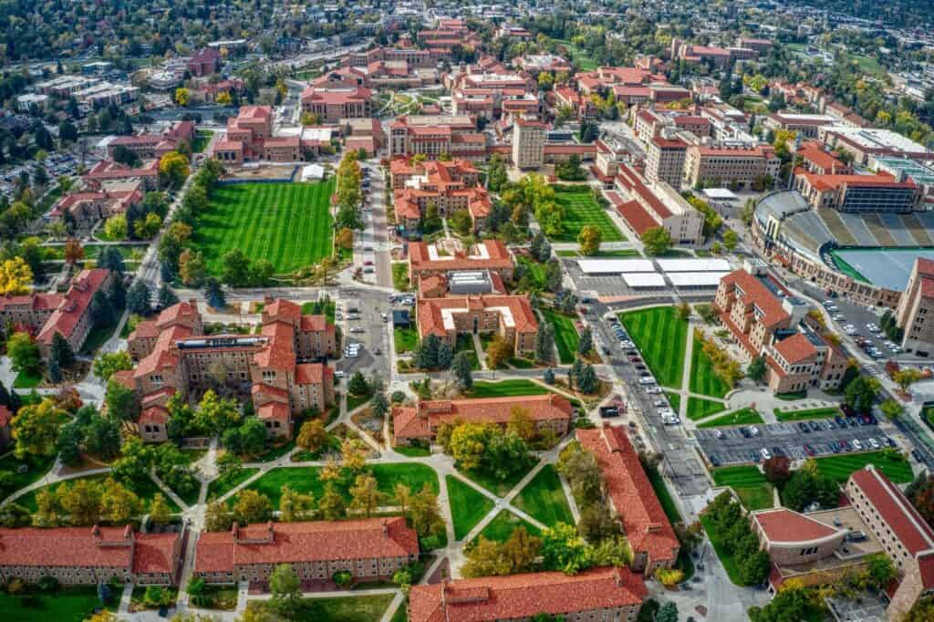 Aerial view of university campus with red-roofed buildings and green spaces