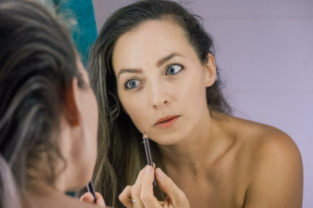 Person gently removing eye makeup with a cotton pad before bed - bump on eyelid causing pain