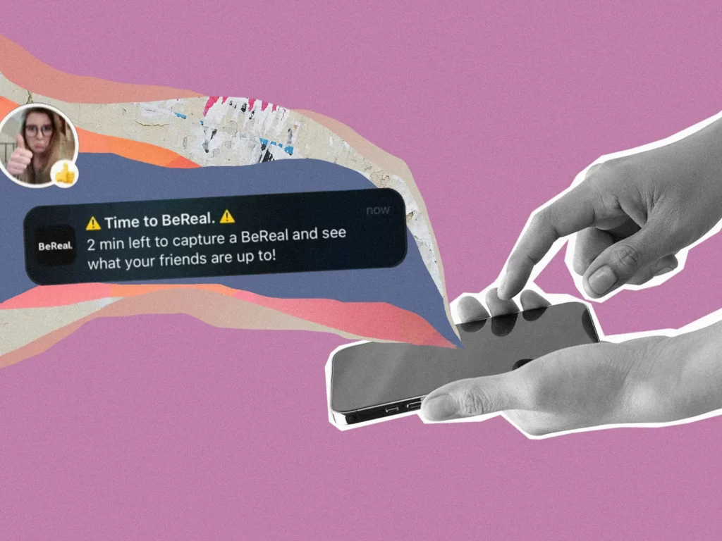 BeReal illustration. A hand holding a phone about to tap onto the screen, with a notification of BeReal asking the user to capture an image