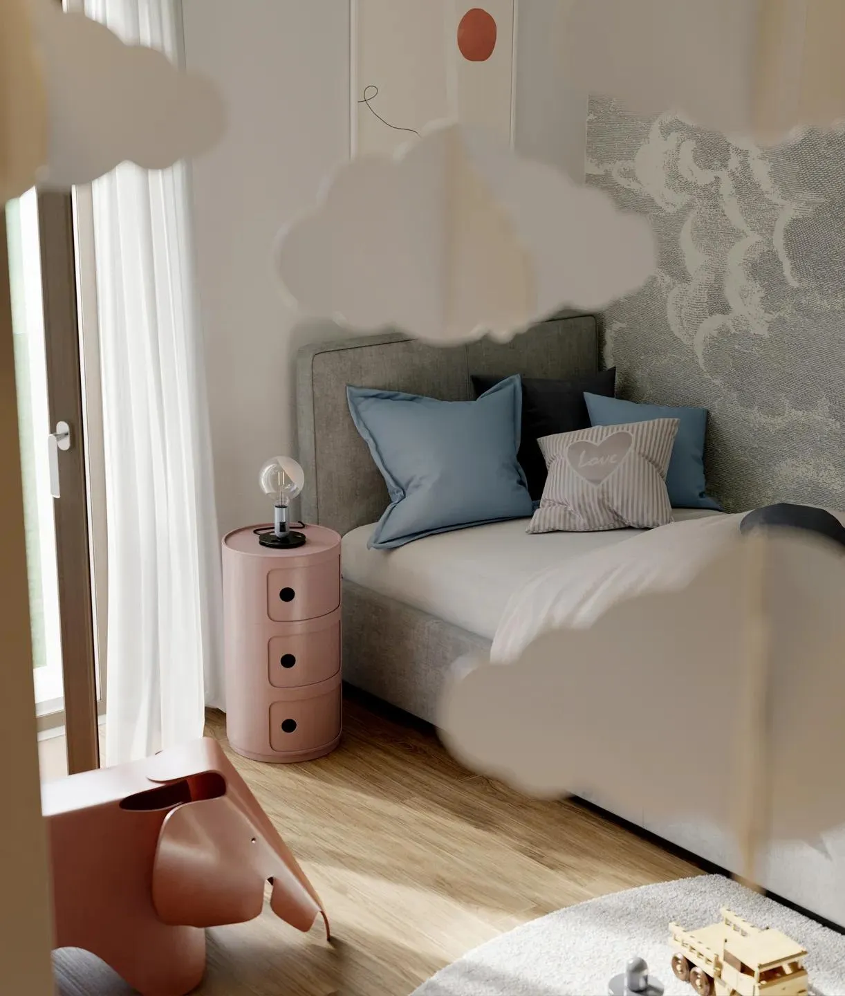 Cameretta con letto grigio, cuscini azzurri e comodino rosa accanto a una lampada.