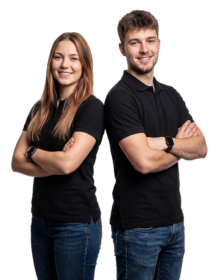 Ein weiblicher und männlicher Lehrling wie diese Rücken an Rücken stehen und in die Kamera lächeln.