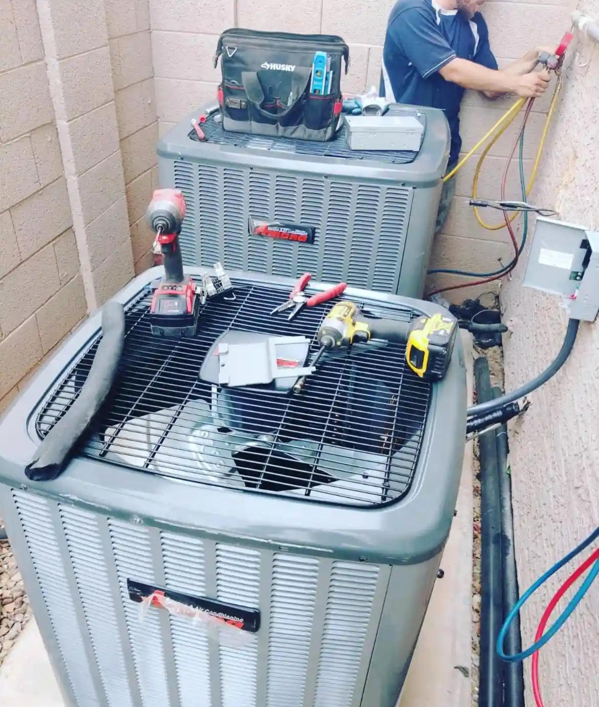 Technician performing AC replacement service, tools and equipment on air conditioning units, San Tan Valley, AZ.