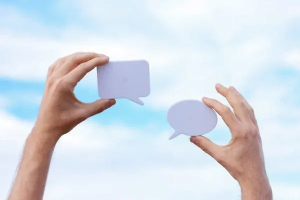 Two hands holding speech bubbles