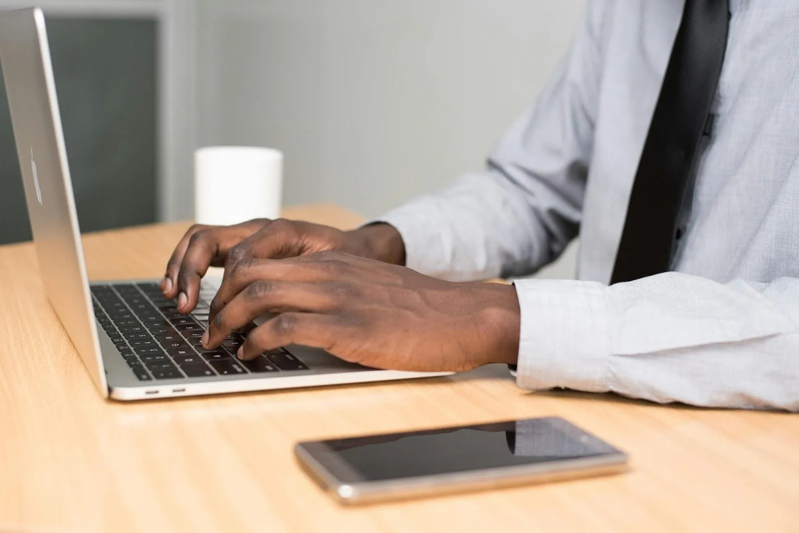 Person wearing white shirt on laptop