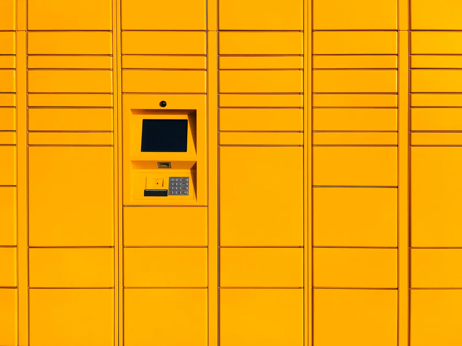 A yellow wall of smart lockers