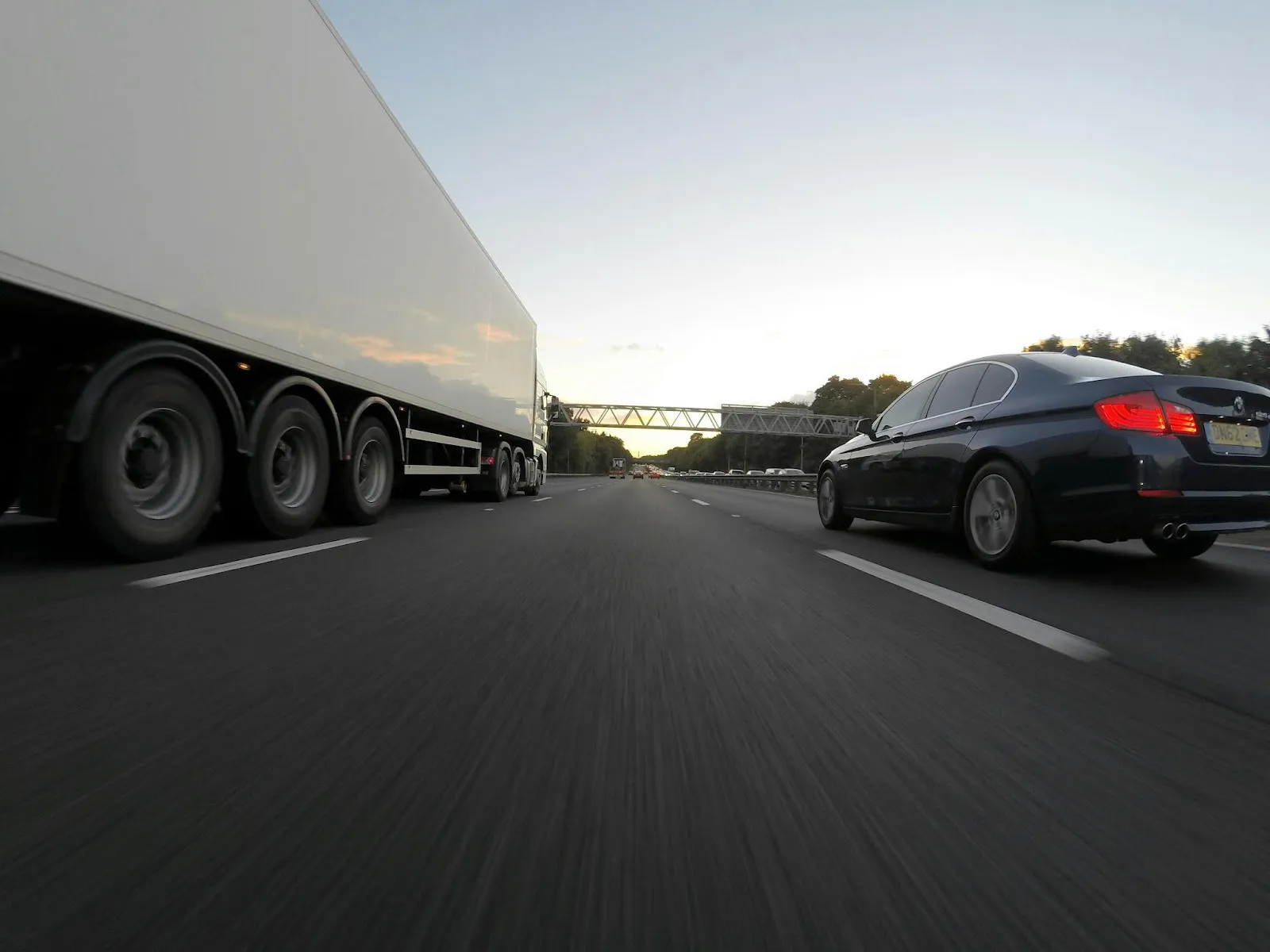 Car and lorry running on road together