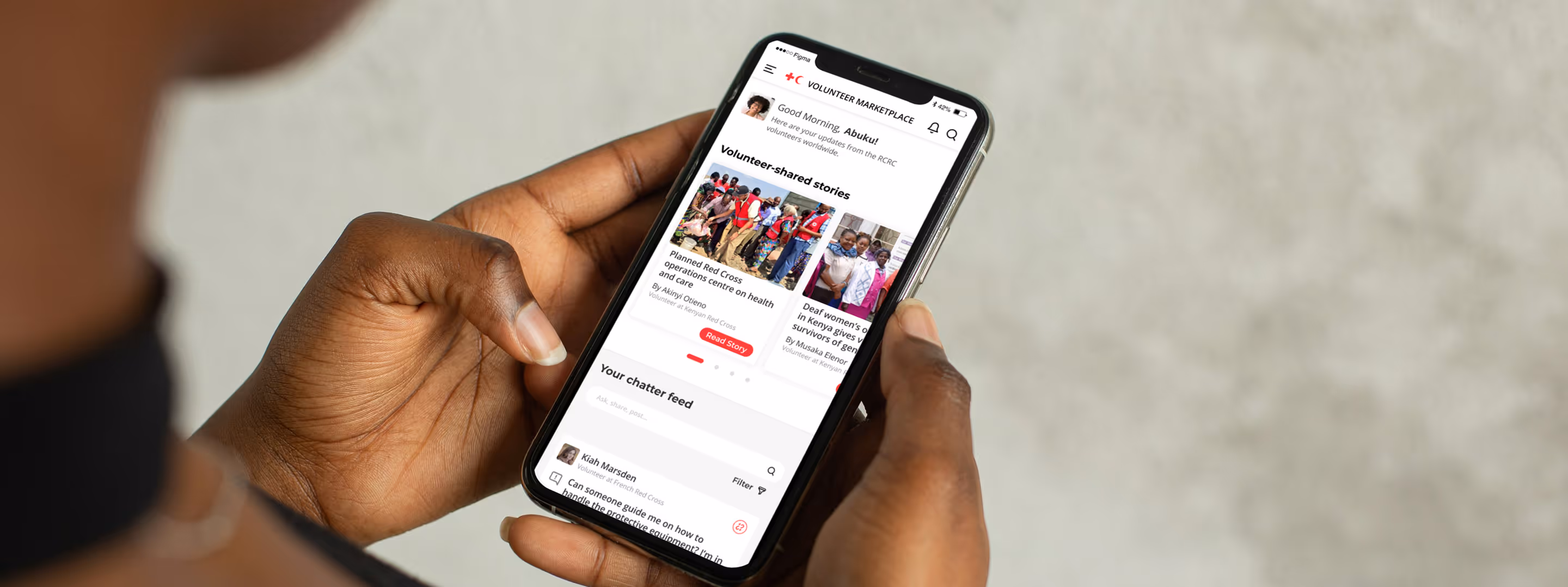 Person holding a mobile phone with the IFRC volunteering app on the screen