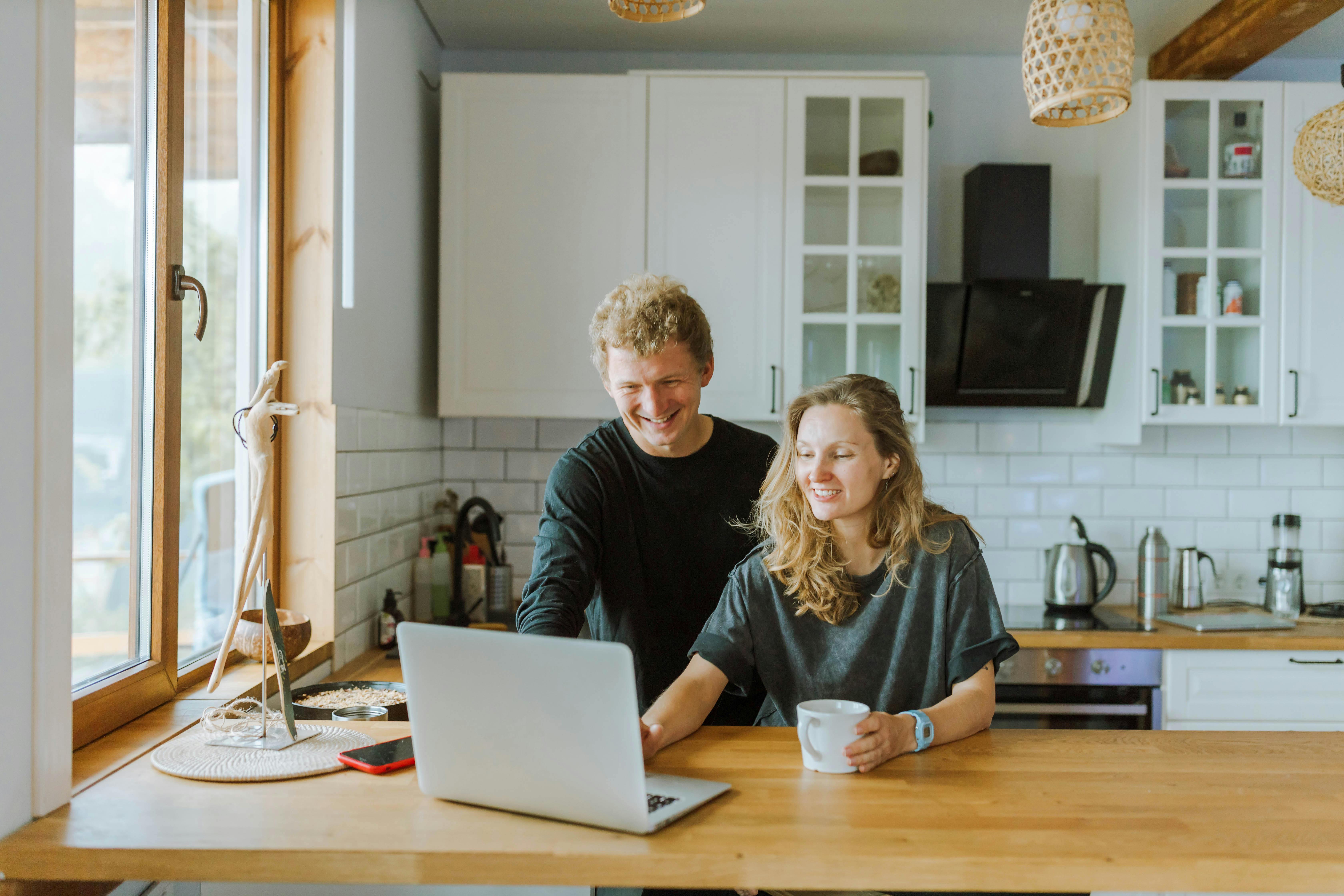 Image of two people working on a laptop