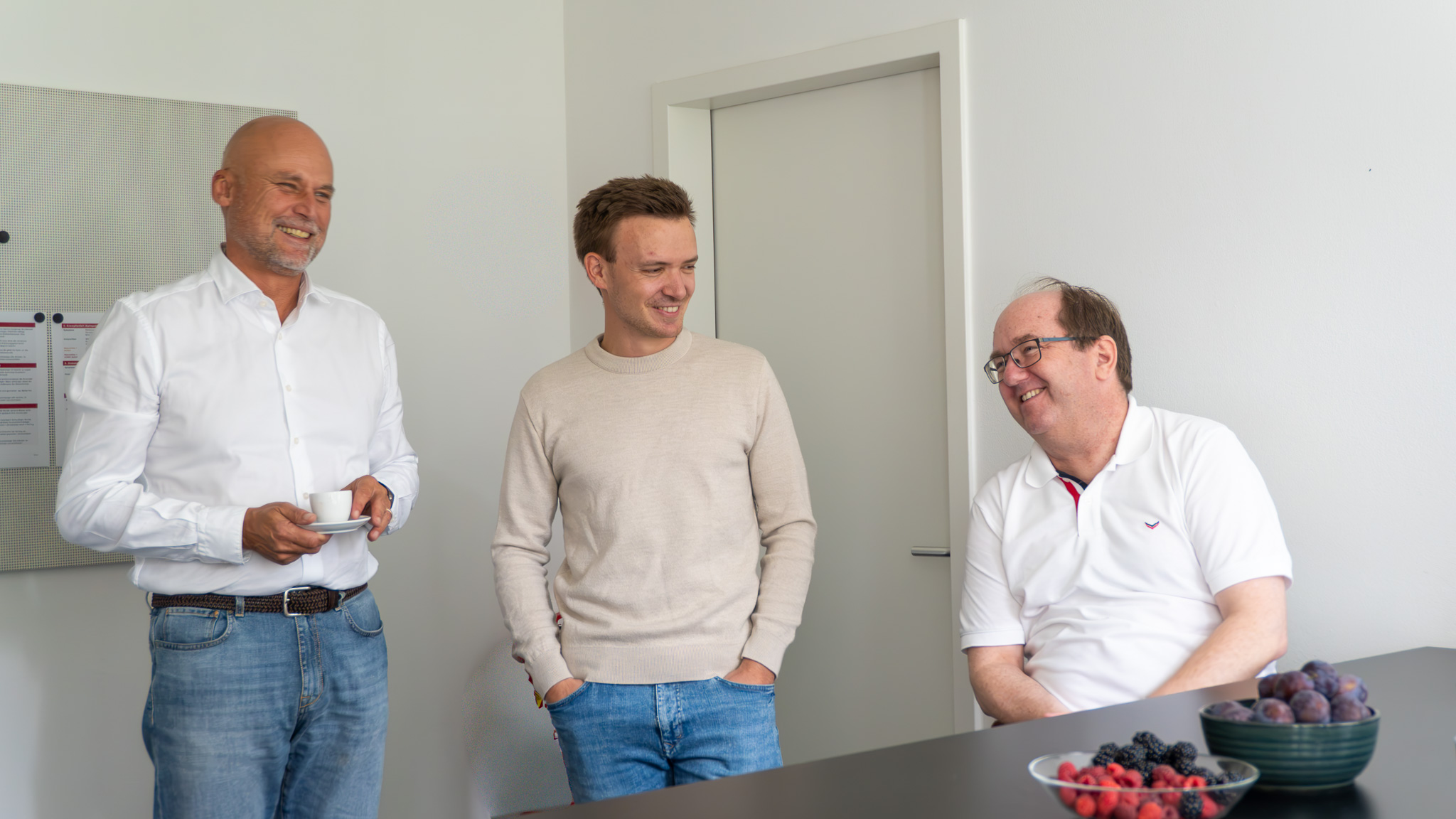 Drei Kollegen im Gespräch in der Büroküche