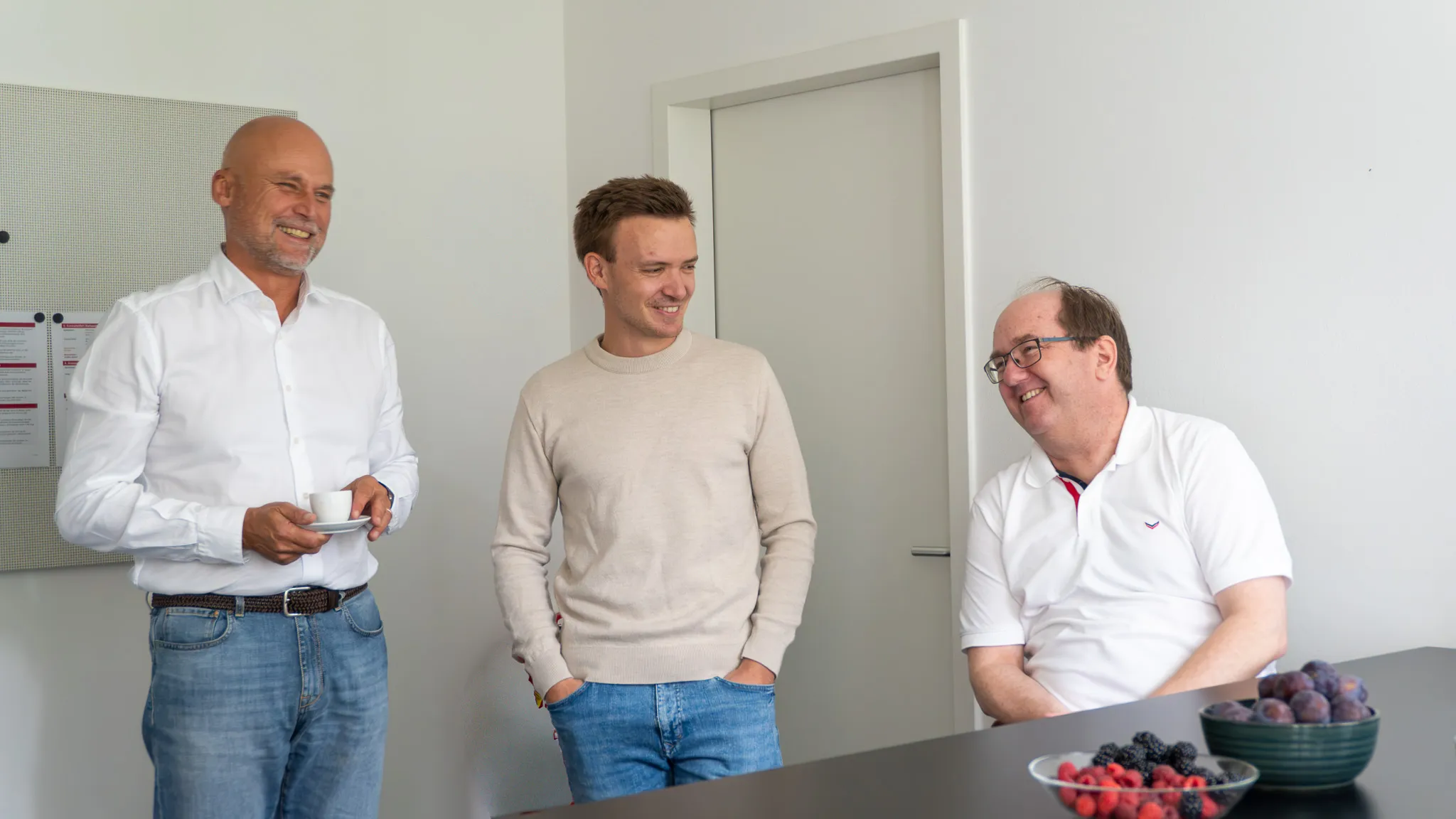 Drei Kollegen im Gespräch in der Büroküche