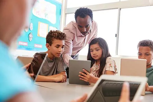 Teacher helping young children in a classroom