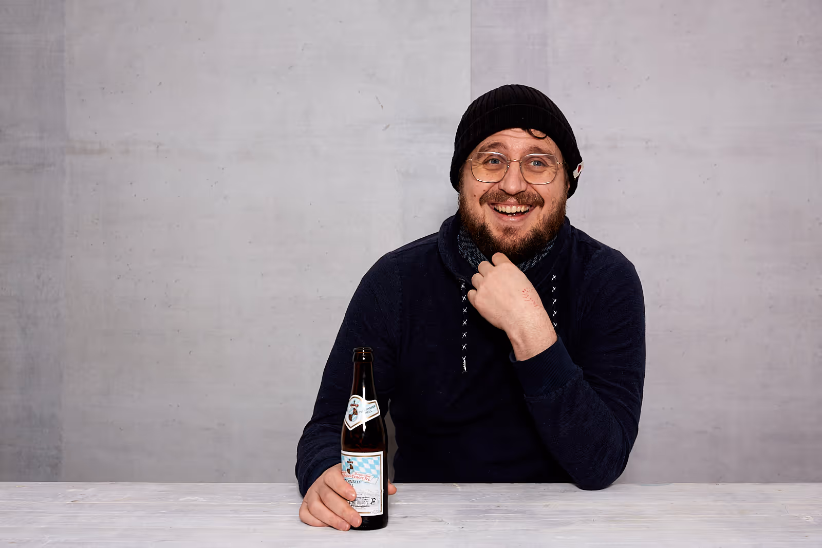 Lächelnder, bärtiger Martin mit Brille und Bier, so macht fathandlen Spass 