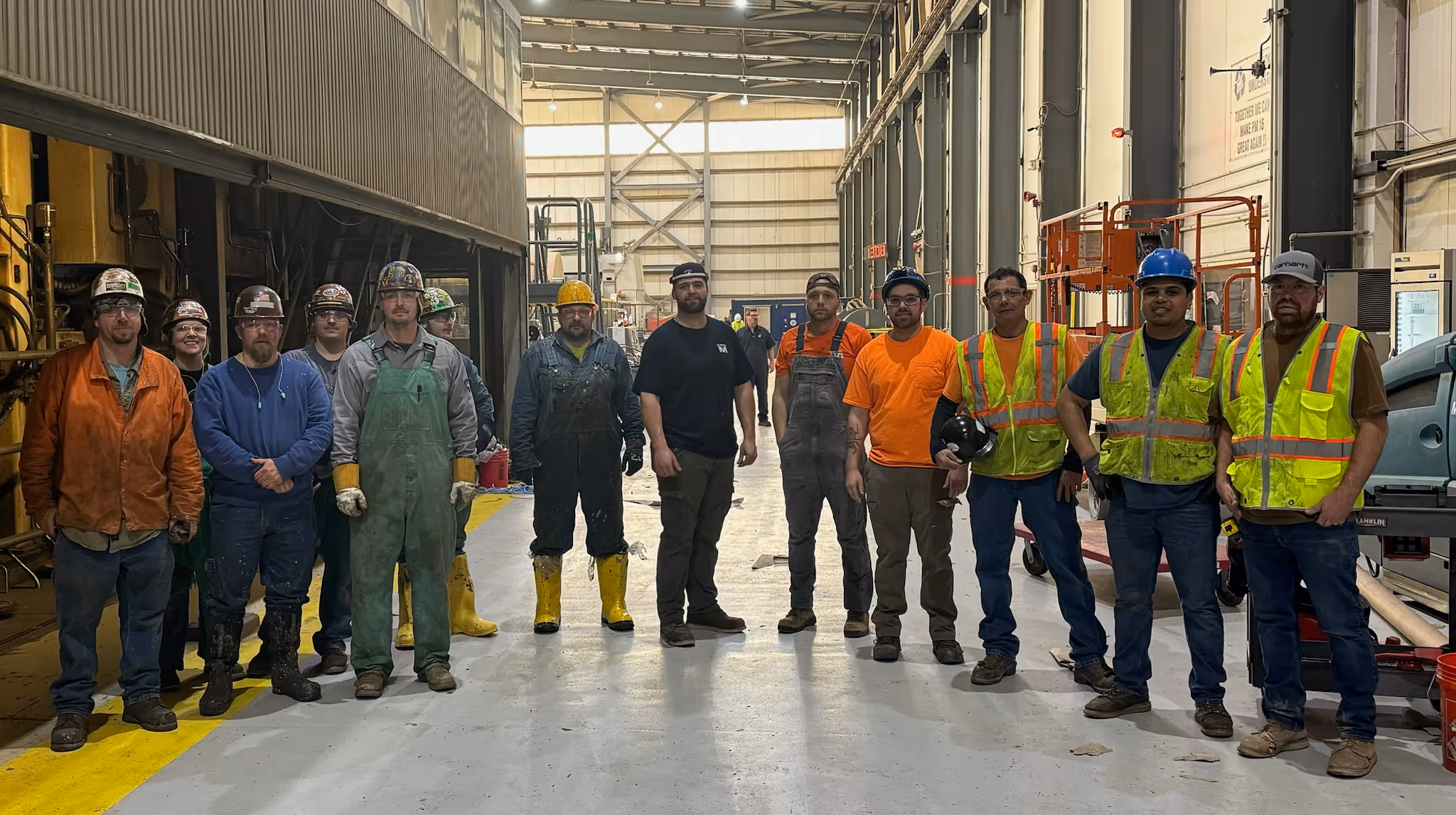 A group of people wearing hardhats and looking at the camera