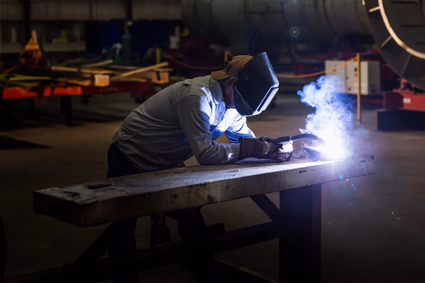 A welder working on a bench