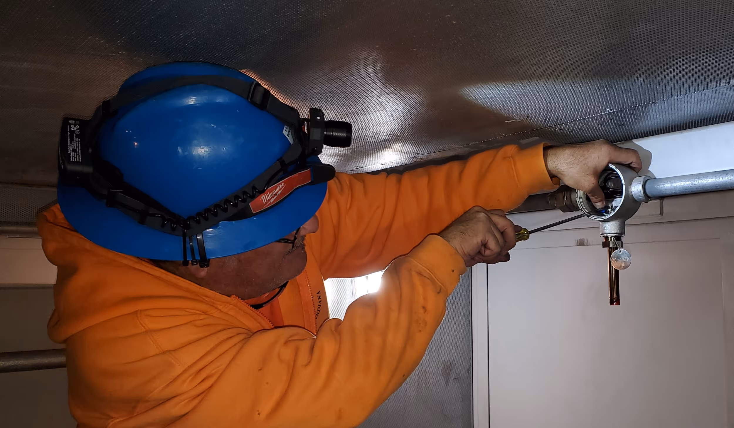 Two people in blue hard hats taking notes