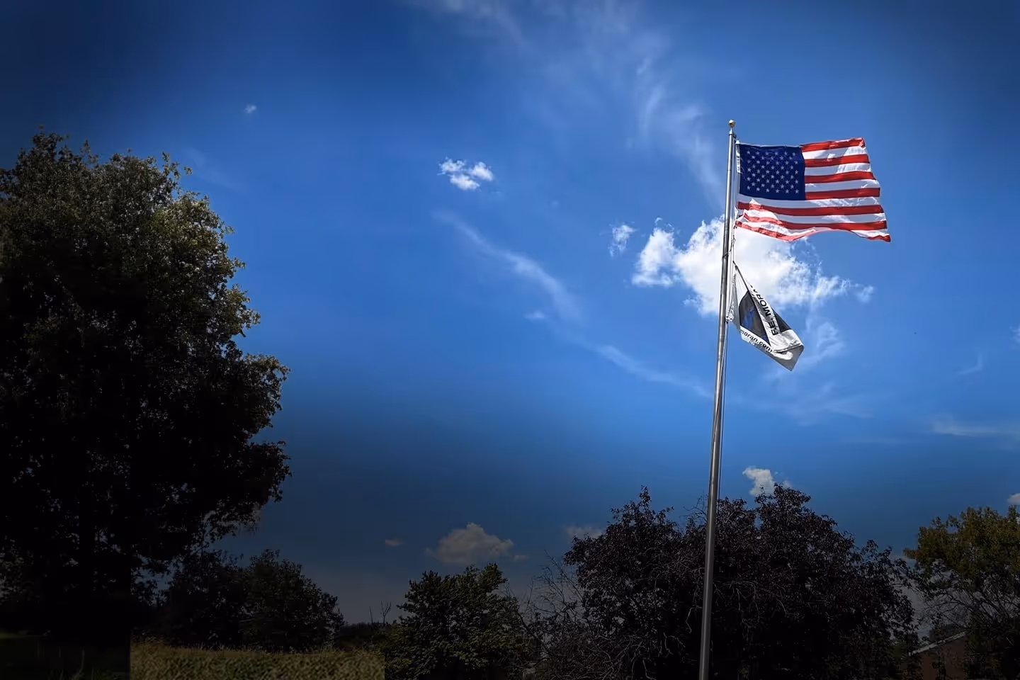 The American flag and FE Moran flag and a blue sky
