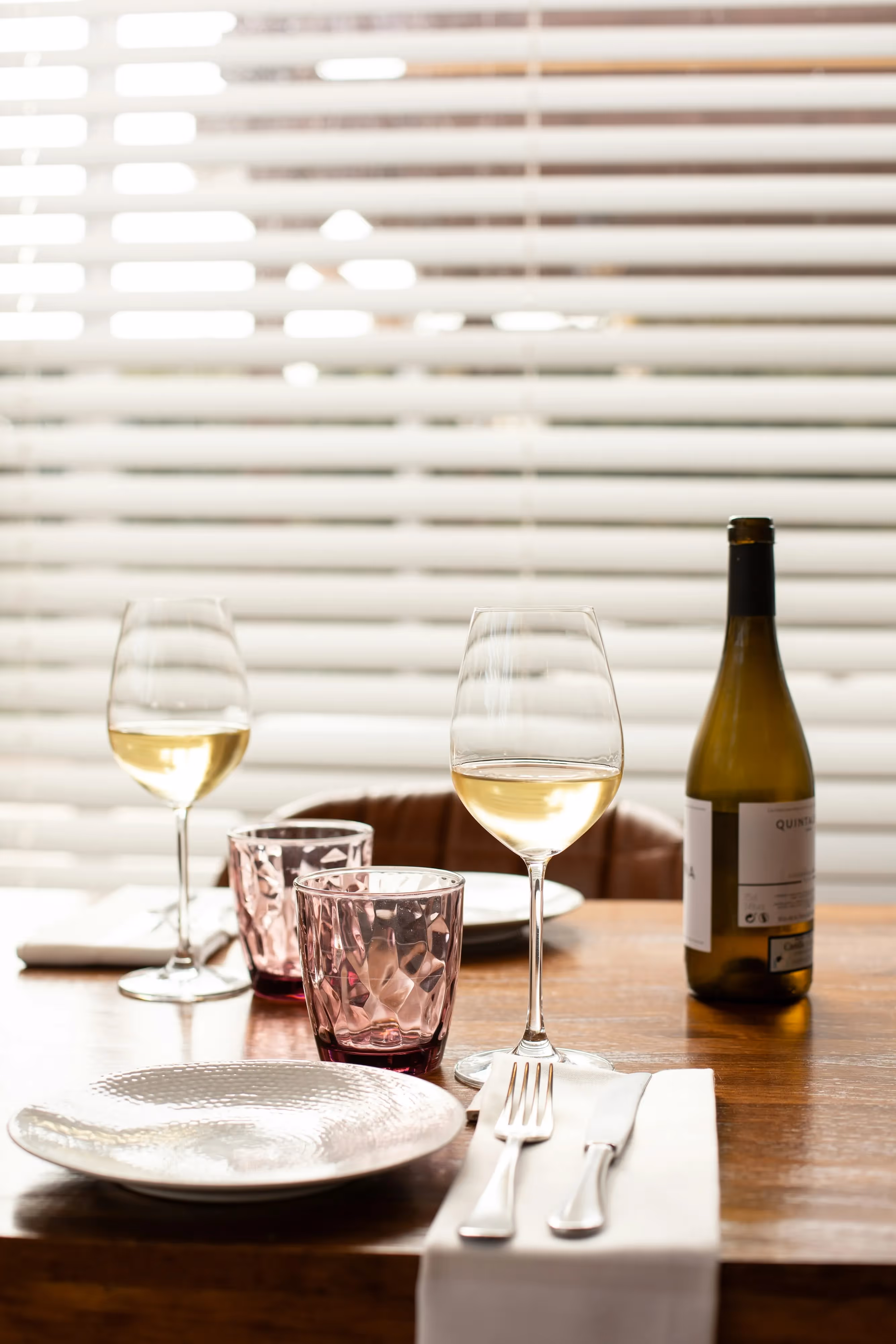 Elegantly set table with wine glasses, a bottle, and place settings, suggesting fine dining or a stylish resident event space near Crossing at 9th in Salt Lake City.