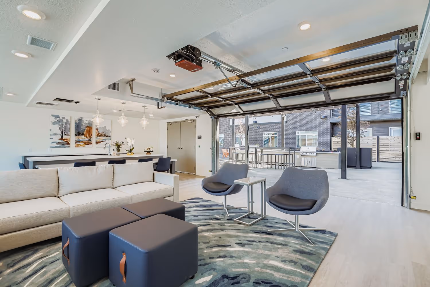 Community Room of Crossing at 9th apartment complex in Salt Lake City, Utah, showing kitchen, seating area and seating area with exterior view.