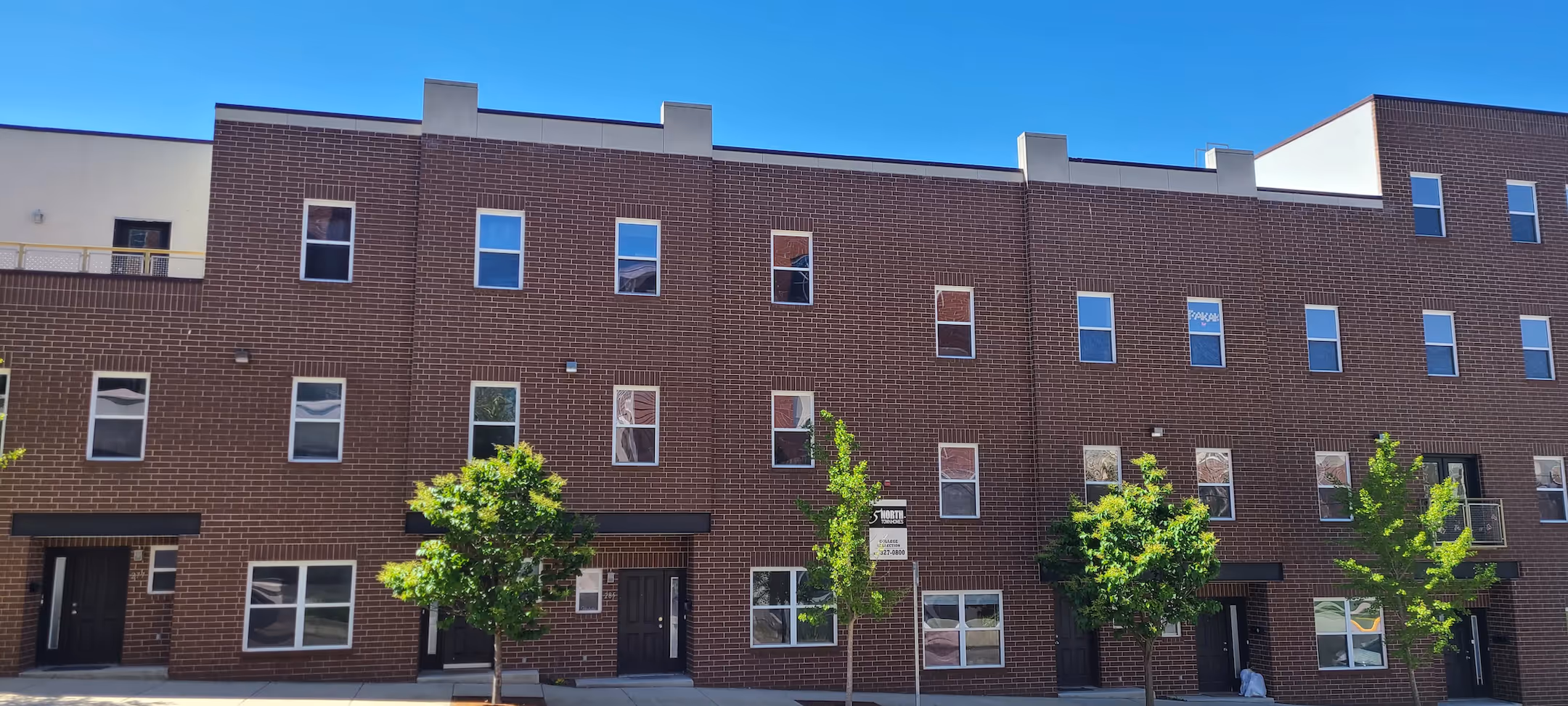 Exterior view of 5 North multi-story brick apartment building with modern windows and sidewalk in Bloomington, Indiana.