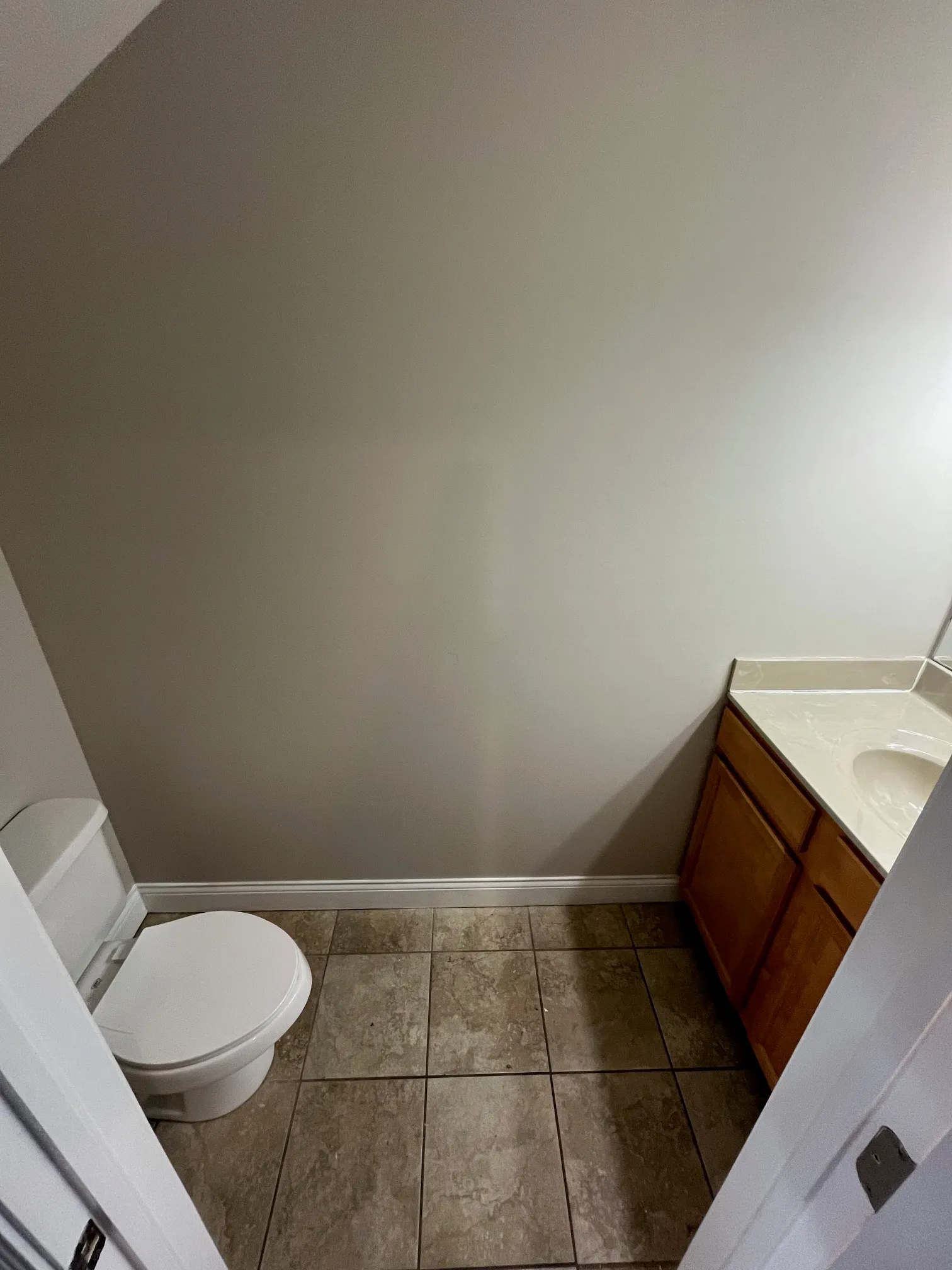 Apartment bathroom at 5 North featuring neutral tile flooring, wooden vanity with white countertop, and clean modern fixtures.