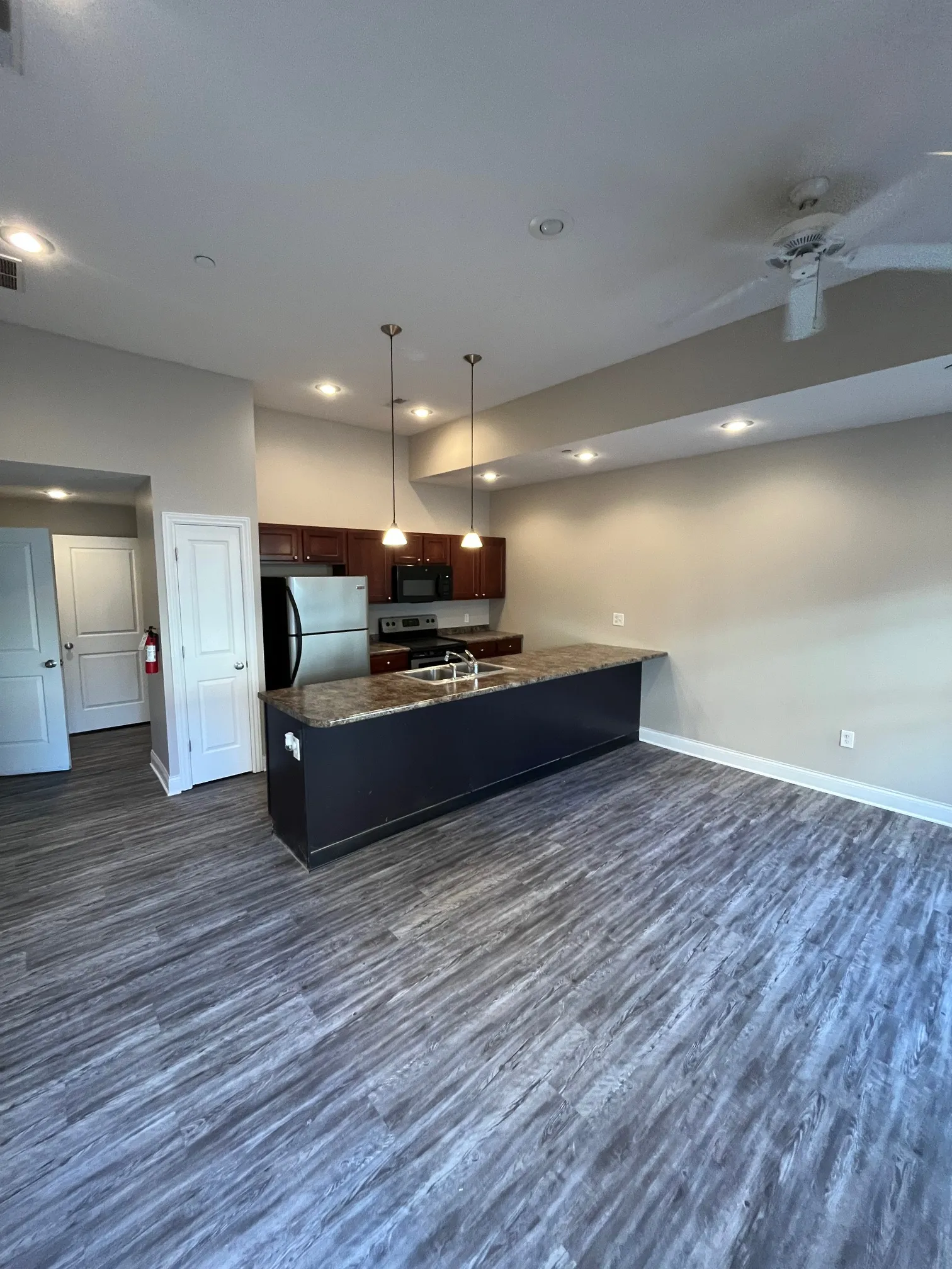 View of 5 North apartment interior showing transition from kitchen island to open living space with hardwood-style floors.