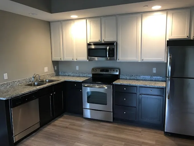 Detailed view of a 7 Ten kitchen with dark espresso lower cabinets, white upper cabinets, and a stainless steel microwave.
