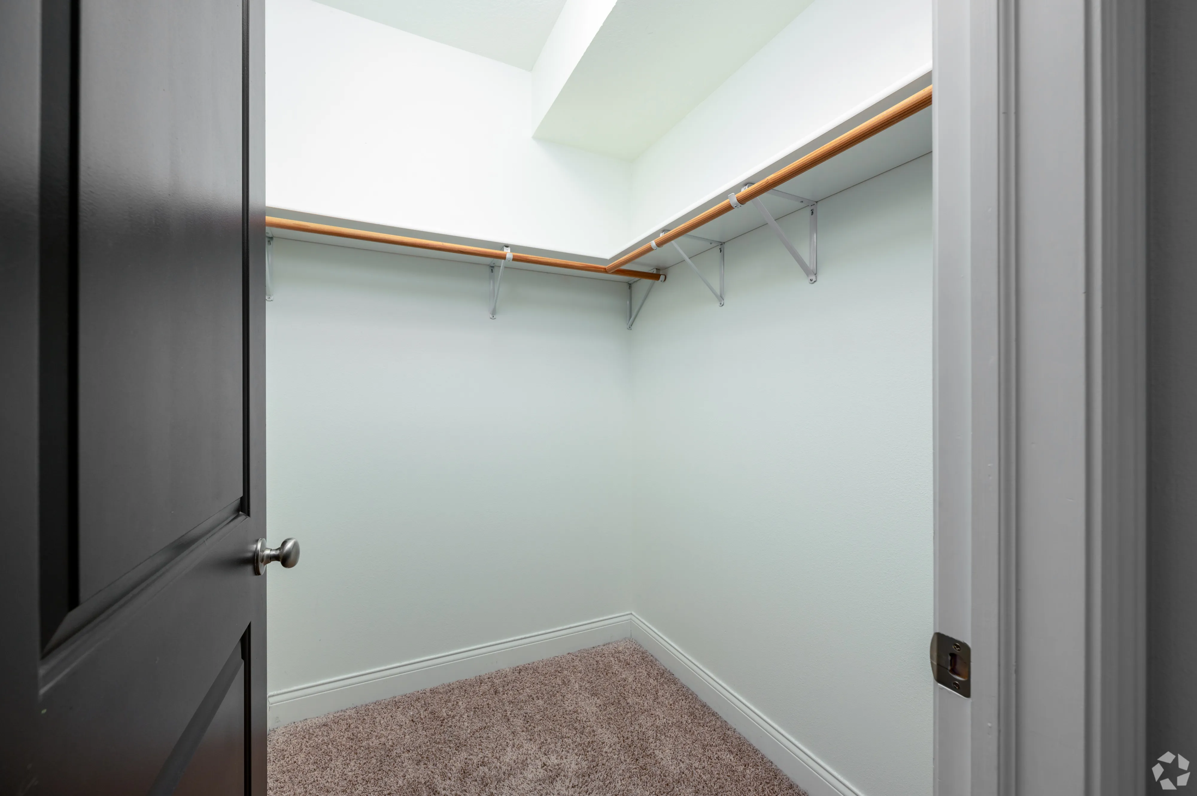 Corner view of an apartment walk-in closet at 7 Ten with ample shelving and hanging space.